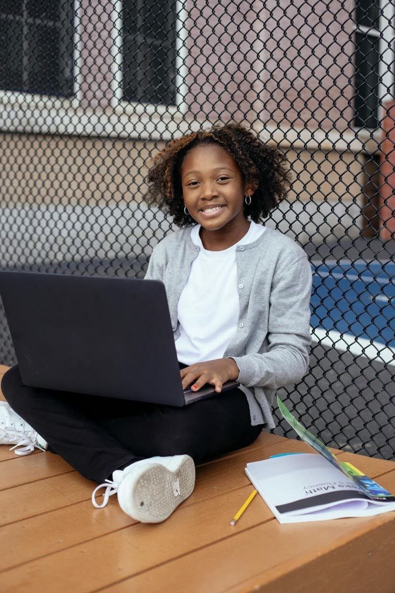 Apprenante avec ordinateur et cahiers